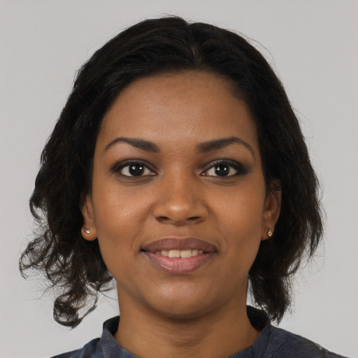 Joyful black young-adult female with long  black hair and brown eyes