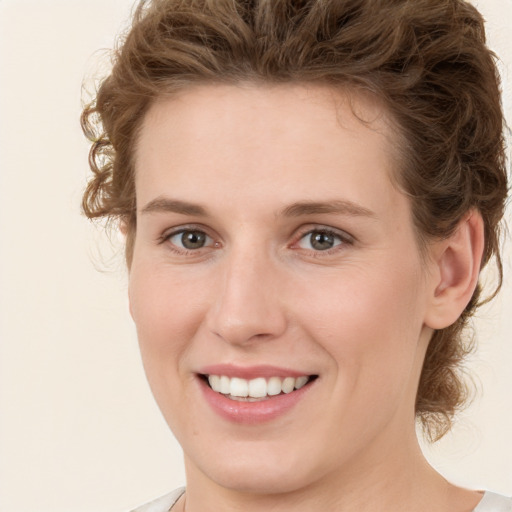 Joyful white young-adult female with medium  brown hair and green eyes