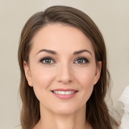 Joyful white young-adult female with long  brown hair and green eyes