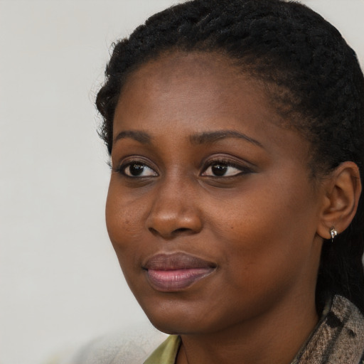 Joyful black young-adult female with short  black hair and brown eyes