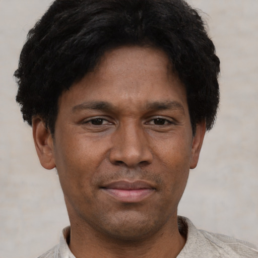 Joyful black adult male with short  black hair and brown eyes