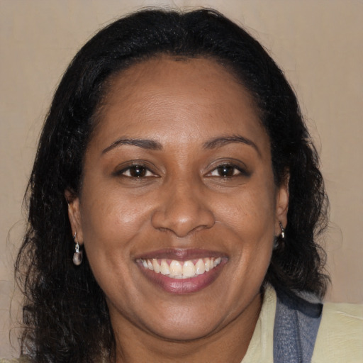 Joyful black adult female with medium  brown hair and brown eyes