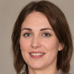 Joyful white adult female with medium  brown hair and green eyes