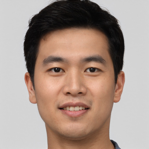 Joyful asian young-adult male with short  brown hair and brown eyes