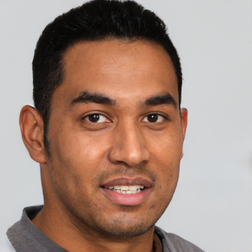 Joyful latino young-adult male with short  black hair and brown eyes
