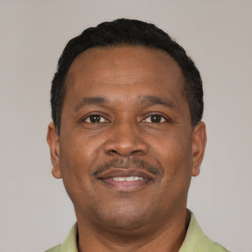 Joyful black adult male with short  black hair and brown eyes
