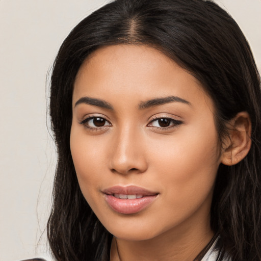 Joyful latino young-adult female with long  brown hair and brown eyes