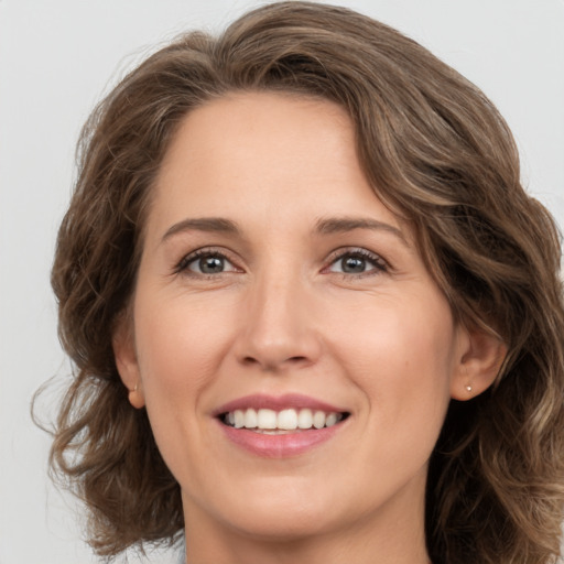 Joyful white young-adult female with medium  brown hair and green eyes