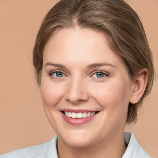 Joyful white young-adult female with medium  brown hair and grey eyes