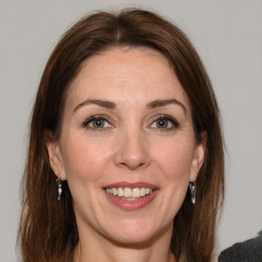 Joyful white adult female with medium  brown hair and grey eyes