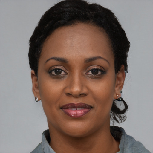 Joyful black young-adult female with short  black hair and brown eyes