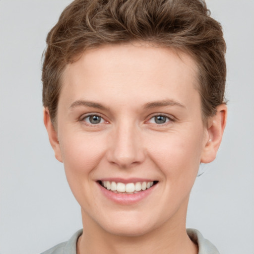 Joyful white young-adult female with short  brown hair and grey eyes