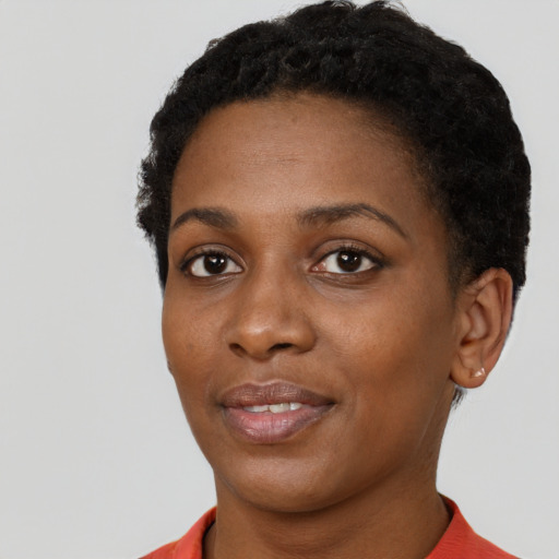 Joyful black young-adult female with short  black hair and brown eyes