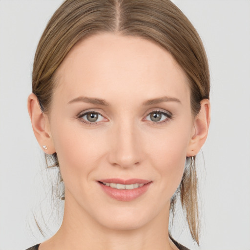 Joyful white young-adult female with long  brown hair and grey eyes