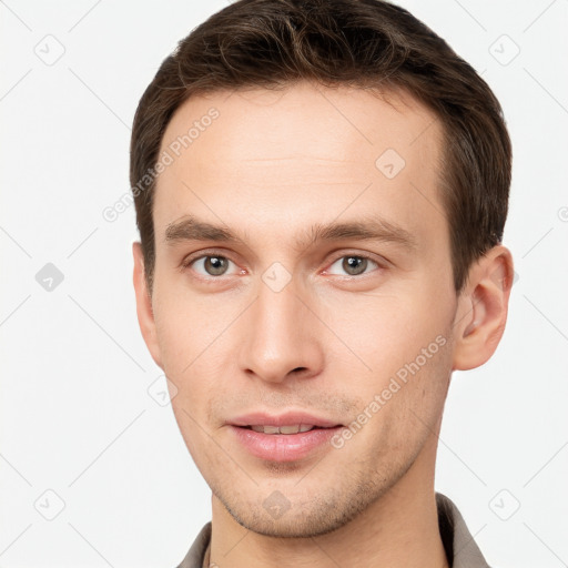 Joyful white young-adult male with short  brown hair and grey eyes