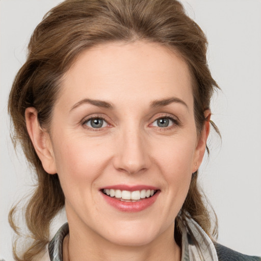 Joyful white young-adult female with medium  brown hair and grey eyes