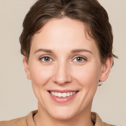 Joyful white young-adult female with short  brown hair and grey eyes