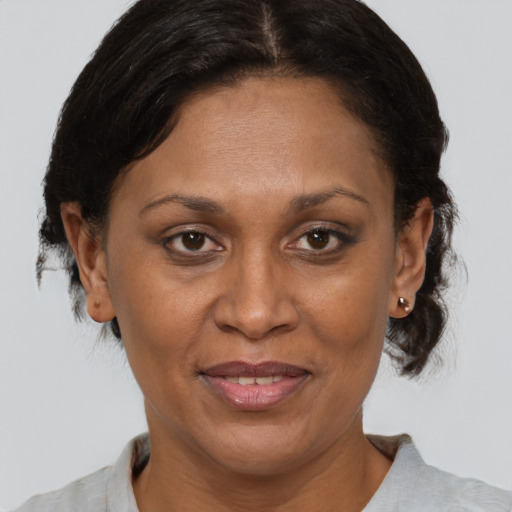 Joyful black adult female with medium  brown hair and brown eyes