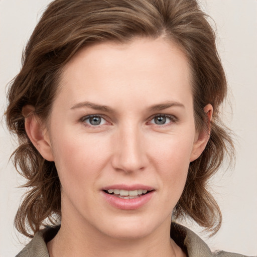 Joyful white young-adult female with medium  brown hair and grey eyes