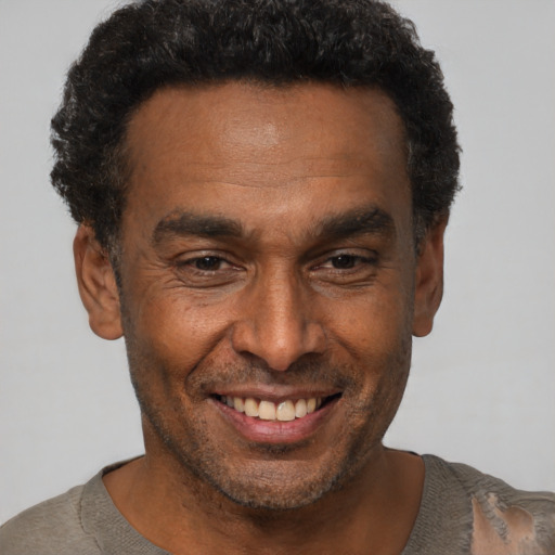 Joyful black adult male with short  brown hair and brown eyes