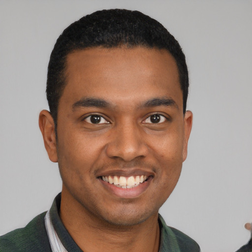 Joyful black young-adult male with short  black hair and brown eyes