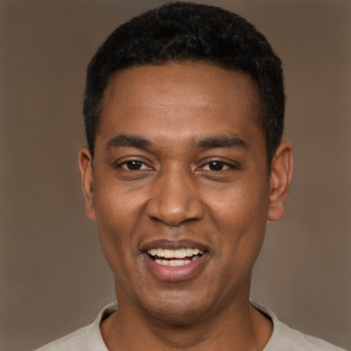 Joyful black young-adult male with short  black hair and brown eyes