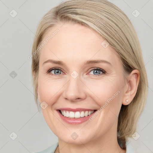 Joyful white young-adult female with medium  brown hair and blue eyes