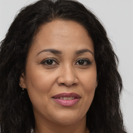 Joyful latino adult female with long  brown hair and brown eyes