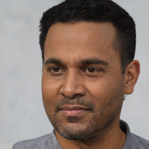 Joyful latino adult male with short  black hair and brown eyes