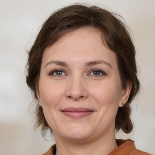 Joyful white adult female with medium  brown hair and brown eyes