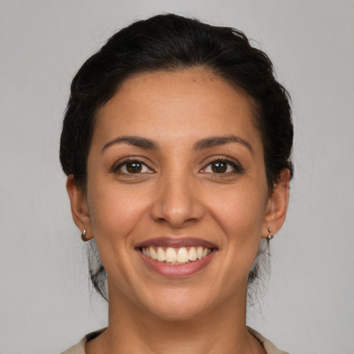 Joyful latino young-adult female with short  brown hair and brown eyes