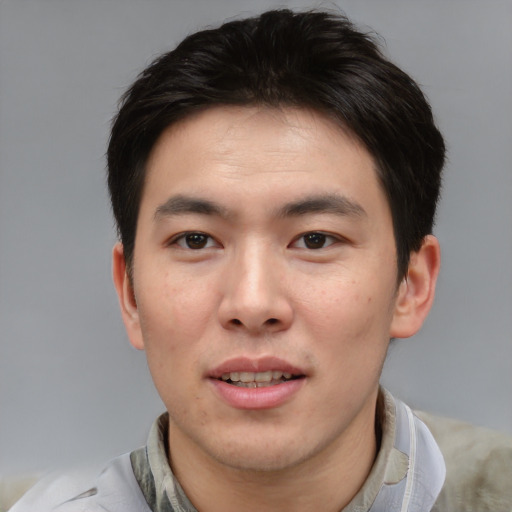 Joyful asian young-adult male with short  brown hair and brown eyes