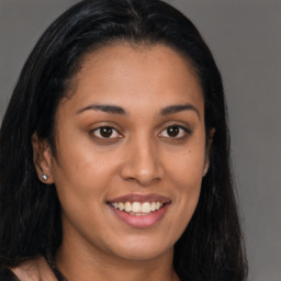 Joyful latino young-adult female with long  brown hair and brown eyes