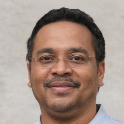 Joyful latino adult male with short  black hair and brown eyes