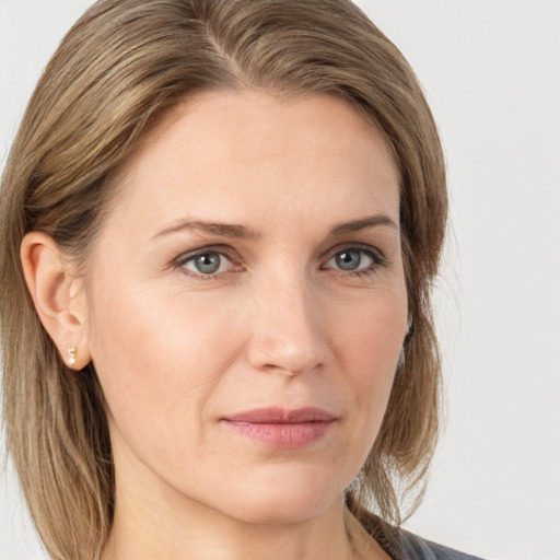 Joyful white adult female with medium  brown hair and grey eyes