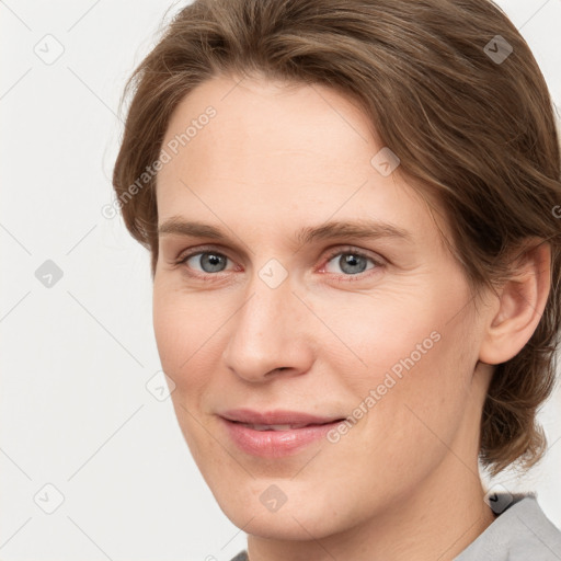 Joyful white young-adult female with medium  brown hair and grey eyes