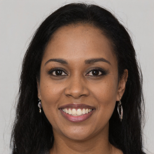 Joyful black young-adult female with long  brown hair and brown eyes