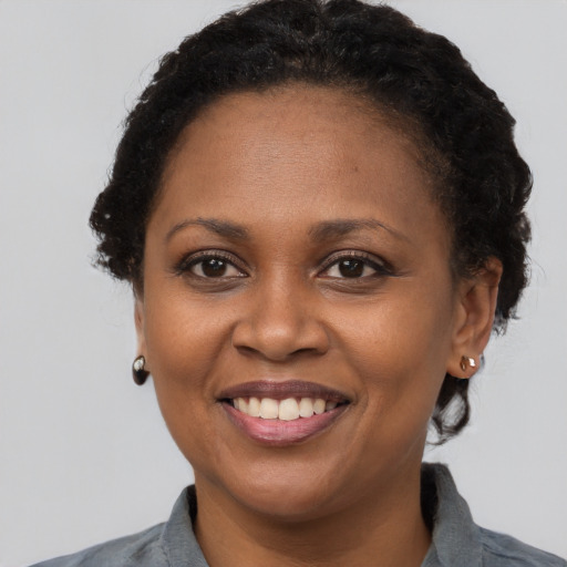 Joyful black young-adult female with short  brown hair and brown eyes