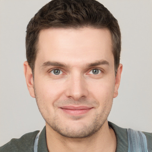 Joyful white young-adult male with short  brown hair and grey eyes