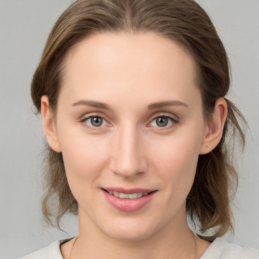 Joyful white young-adult female with medium  brown hair and grey eyes