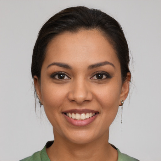 Joyful latino young-adult female with medium  brown hair and brown eyes
