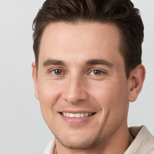 Joyful white young-adult male with short  brown hair and brown eyes