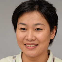 Joyful white adult female with medium  brown hair and brown eyes