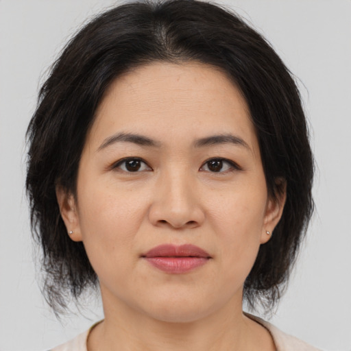 Joyful asian adult female with medium  brown hair and brown eyes