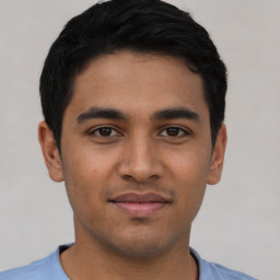 Joyful latino young-adult male with short  black hair and brown eyes