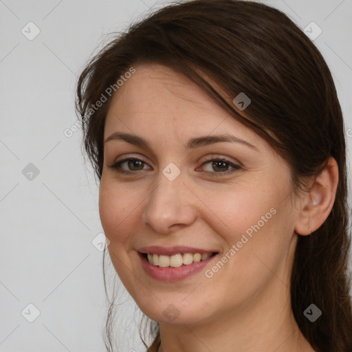 Joyful white young-adult female with long  brown hair and brown eyes