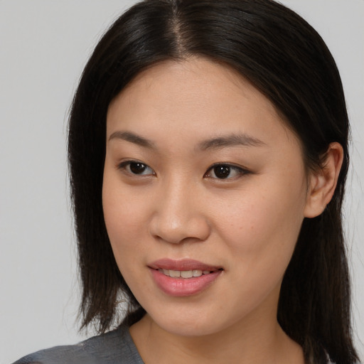 Joyful asian young-adult female with long  brown hair and brown eyes