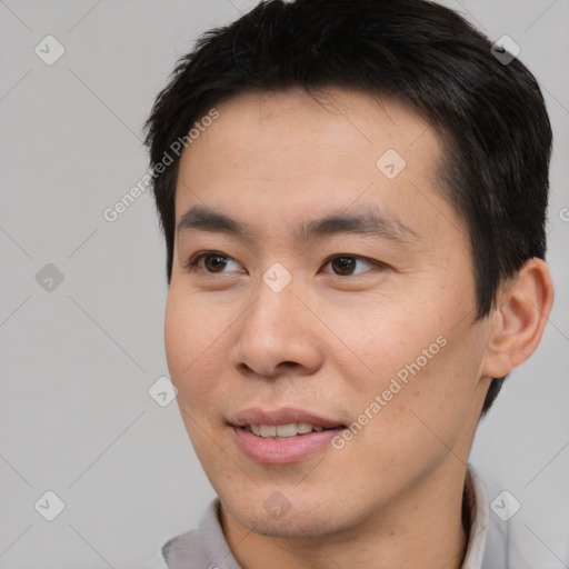 Joyful asian young-adult male with short  brown hair and brown eyes