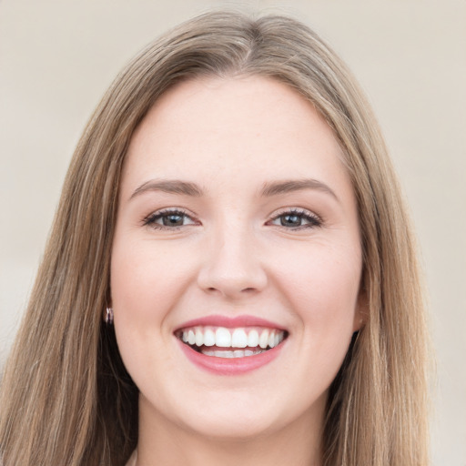 Joyful white young-adult female with long  brown hair and grey eyes