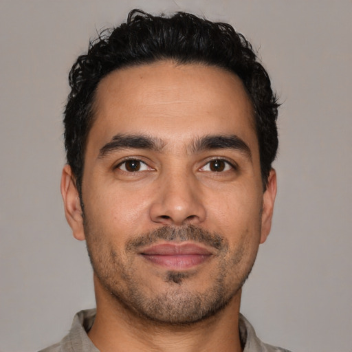Joyful latino young-adult male with short  black hair and brown eyes